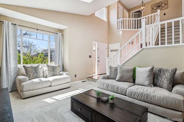 12559 W Crestline Dr, Littleton, CO 80127 - carpeted living room with baseboards, stairway, a chandelier, and a towering ceiling