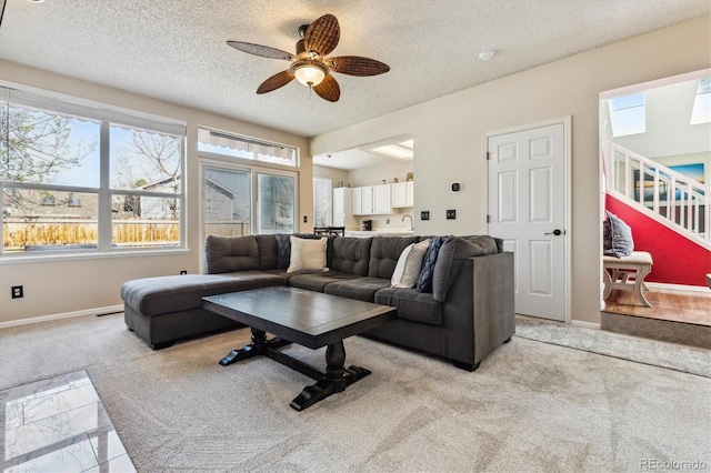 12559 W Crestline Dr, Littleton, CO 80127 - living room with ceiling fan, a textured ceiling, light colored carpet, stairway, and baseboards