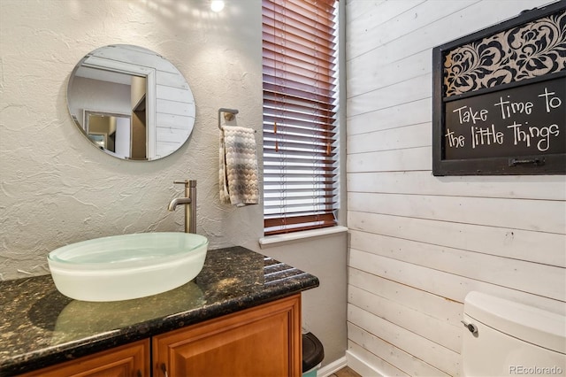12559 W Crestline Dr, Littleton, CO 80127 - half bathroom featuring toilet, wood walls, and vanity