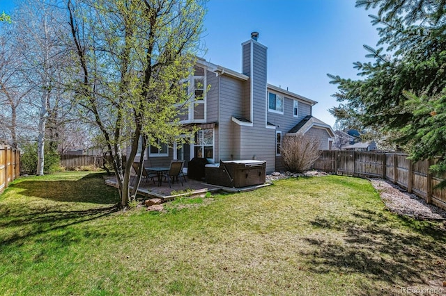 12559 W Crestline Dr, Littleton, CO 80127 - rear view of house featuring a patio area, a fenced backyard, a lawn, and a hot tub