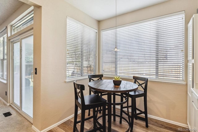 12559 W Crestline Dr, Littleton, CO 80127 - dining space with visible vents, baseboards, wood finished floors, and a healthy amount of sunlight