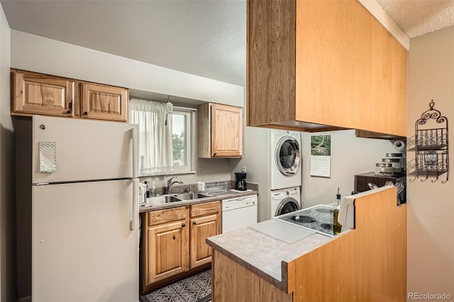 1250 S Monaco Street Parkway Unit 49, Denver, CO 80224 - kitchen featuring white appliances, estacked washer and dryer, a textured ceiling, and light countertops