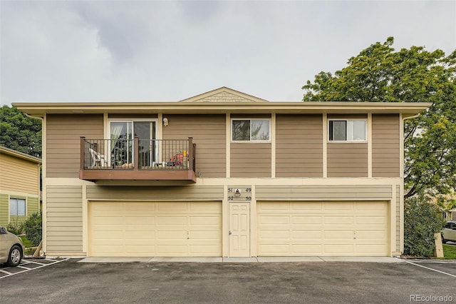 1250 S Monaco Street Parkway Unit 49, Denver, CO 80224 - view of front of house featuring a balcony, an attached garage, and driveway