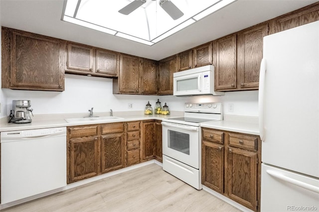 kitchen featuring white appliances, ceiling fan, sink, and light hardwood / wood-style flooring