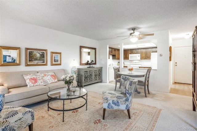 living room featuring sink, a textured ceiling, light carpet, and ceiling fan