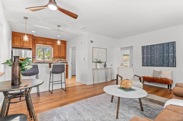 1177 Wabash St, Denver, CO 80220 - living area featuring light wood-type flooring, ceiling fan, and baseboards