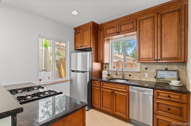 1177 Wabash St, Denver, CO 80220 - kitchen with appliances with stainless steel finishes, a sink, brown cabinets, backsplash, and recessed lighting