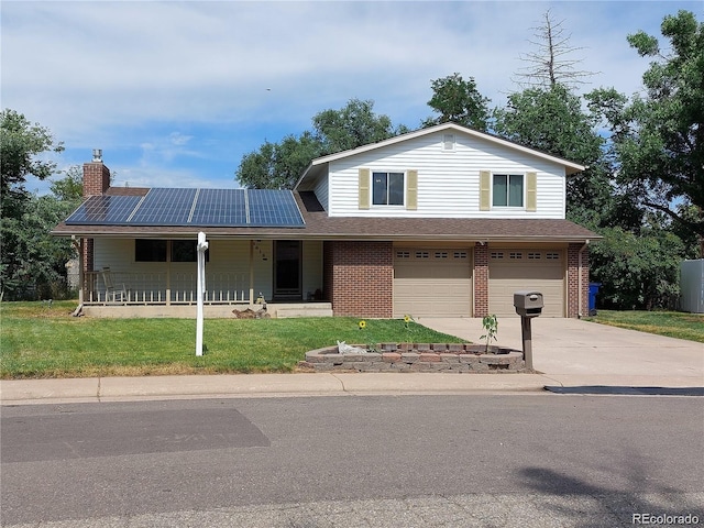 view of front of property with a garage, covered porch, a front lawn, and solar panels