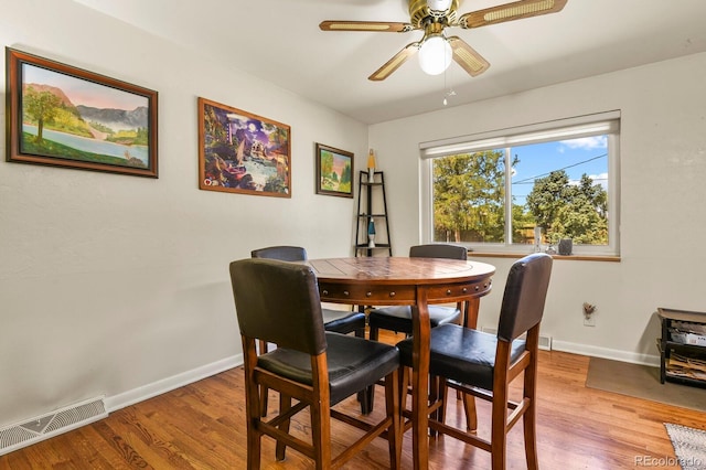 dining space with hardwood / wood-style floors and ceiling fan