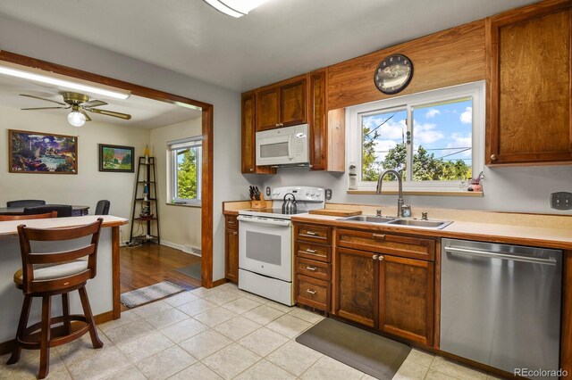 kitchen with ceiling fan, sink, and white appliances