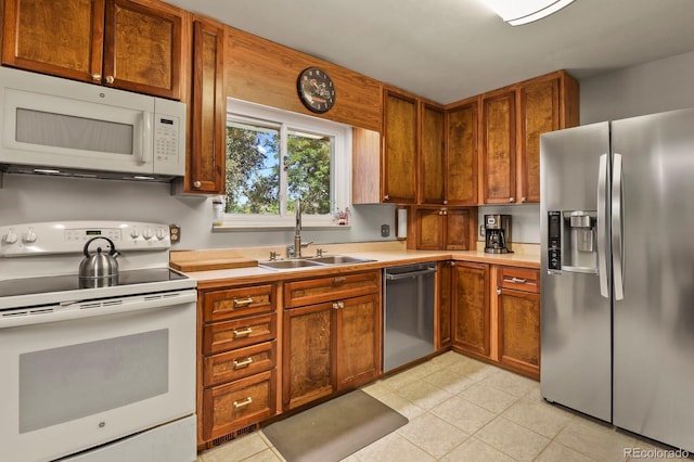 kitchen featuring sink, light tile patterned floors, and stainless steel appliances