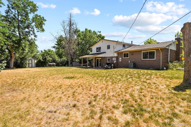 view of yard with a shed, central AC unit, and a patio