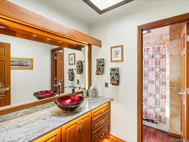 19795 Flint Ln, Morrison, CO 80465 - full bath with vanity, wood finished floors, and a shower with curtain