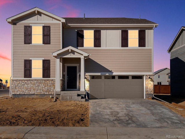 traditional home featuring a garage, stone siding, and driveway