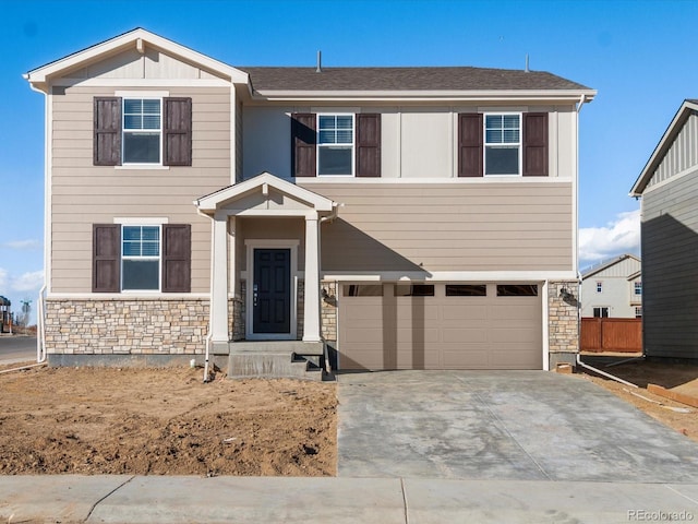 view of front facade with an attached garage, stone siding, board and batten siding, and concrete driveway