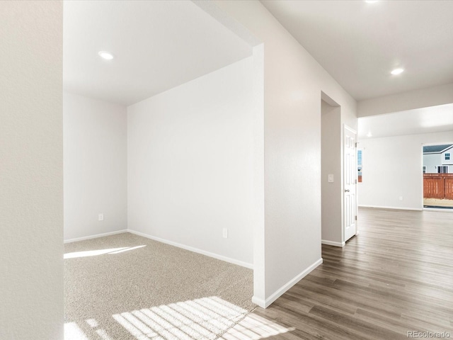 empty room featuring recessed lighting, wood finished floors, and baseboards