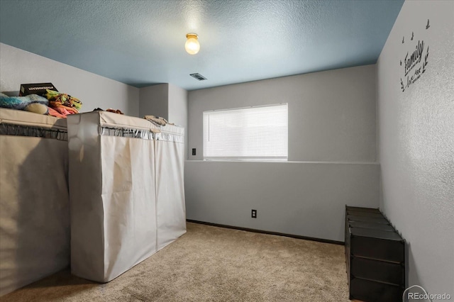 unfurnished bedroom with a textured ceiling and carpet flooring