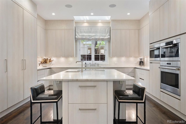 450 Steele St, Denver, CO 80206 - kitchen featuring modern cabinets, stainless steel double oven, a kitchen breakfast bar, dark wood-style floors, and backsplash