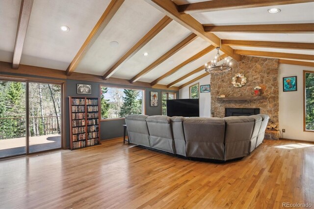 25357 Snyder Ave, Conifer, CO 80433 - living room with light wood-type flooring, a chandelier, a stone fireplace, baseboards, and recessed lighting