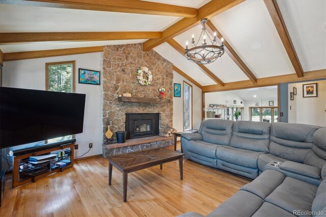 25357 Snyder Ave, Conifer, CO 80433 - living room featuring a chandelier, light wood-style flooring, and a stone fireplace