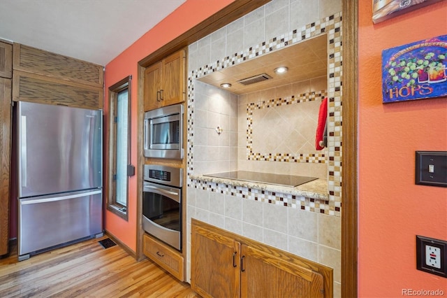 25357 Snyder Ave, Conifer, CO 80433 - kitchen featuring appliances with stainless steel finishes, light wood-type flooring, brown cabinets, and light countertops