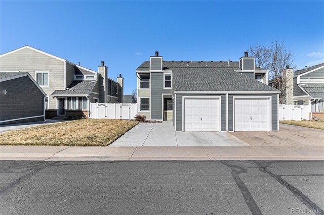 view of front of home featuring a gate, concrete driveway, a garage, and fence