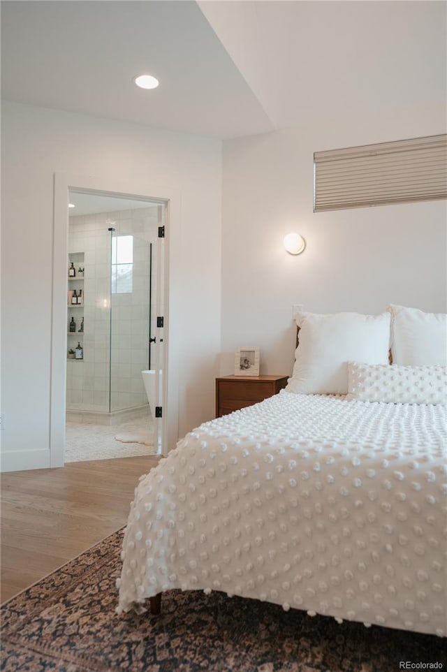 bedroom featuring recessed lighting, ensuite bath, and wood finished floors