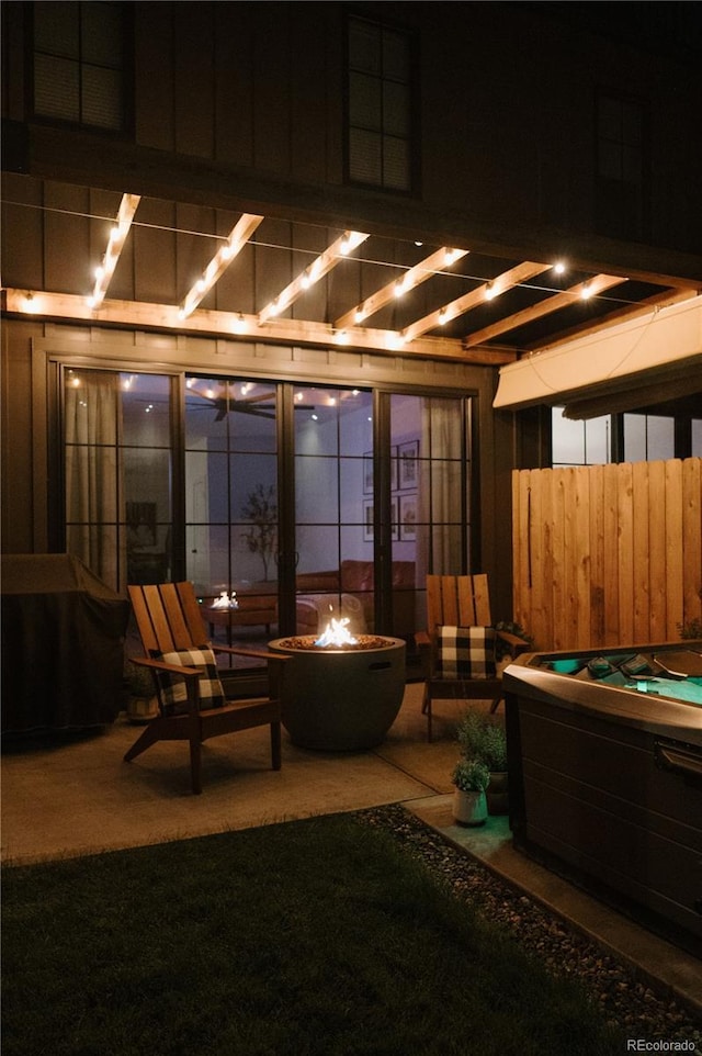 patio at twilight featuring a fire pit and a hot tub