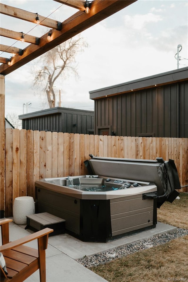 view of patio / terrace with fence, a pergola, and a hot tub