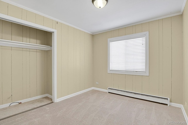 unfurnished bedroom with a baseboard heating unit, a closet, carpet flooring, crown molding, and baseboards