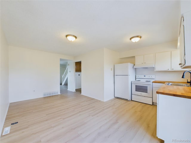 kitchen featuring sink, white appliances, light wood-type flooring, white cabinets, and butcher block counters