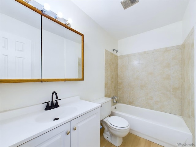 full bathroom featuring hardwood / wood-style floors, toilet, vanity, and tiled shower / bath