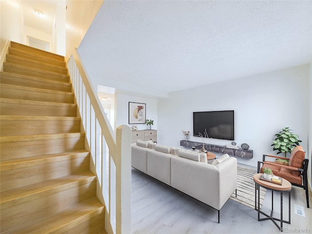 living room featuring a textured ceiling and wood-type flooring