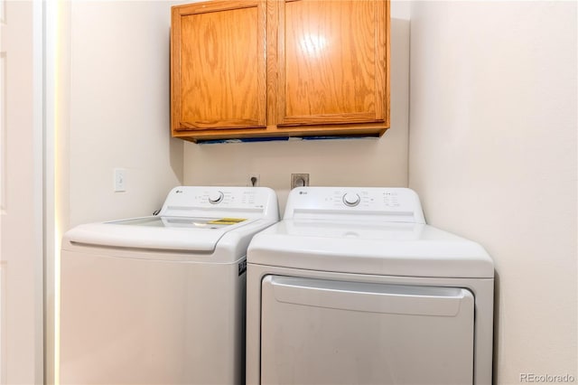 laundry area featuring washer and dryer and cabinets