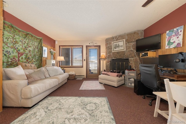 living room featuring baseboard heating, a fireplace, dark carpet, and a textured ceiling