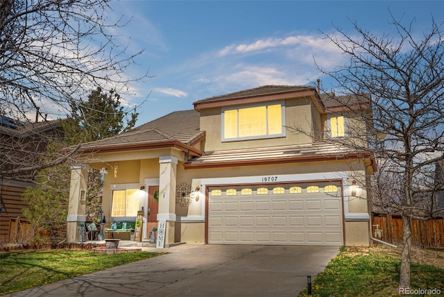 19707 E 59th Pl, Aurora, CO 80019 - view of front facade featuring an attached garage, fence, driveway, and stucco siding