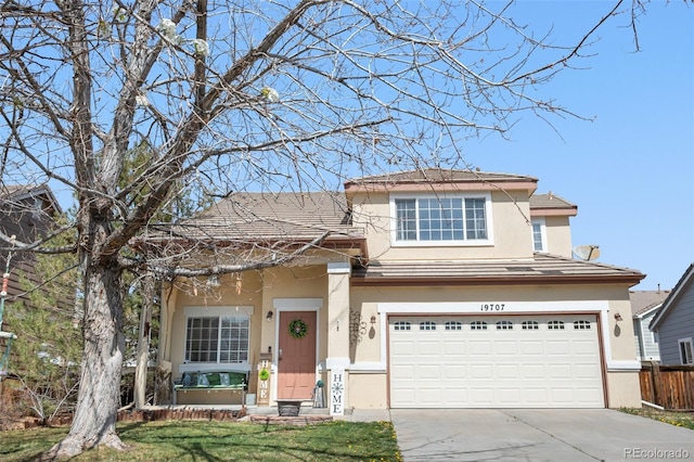 19707 E 59th Pl, Aurora, CO 80019 - traditional-style home featuring a front yard, an attached garage, fence, concrete driveway, and stucco siding
