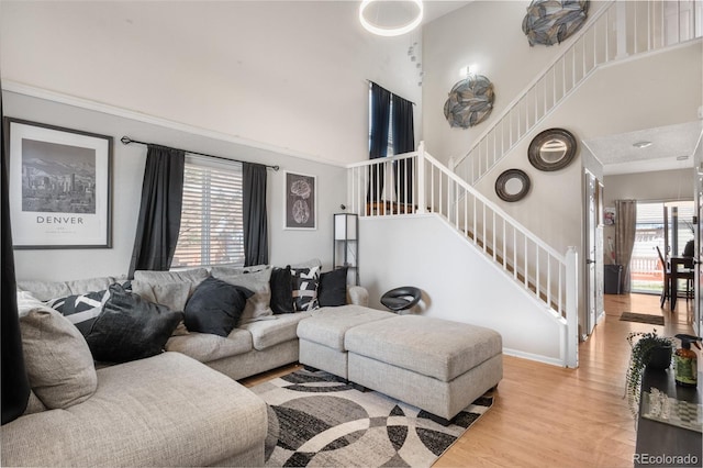 19707 E 59th Pl, Aurora, CO 80019 - living room featuring baseboards, stairway, a high ceiling, and light wood-style floors