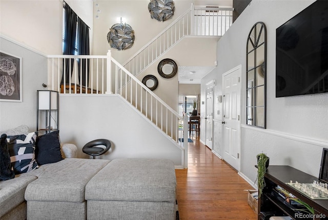19707 E 59th Pl, Aurora, CO 80019 - living room with stairs, a towering ceiling, baseboards, and wood finished floors