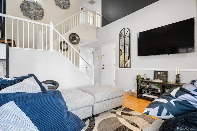 19707 E 59th Pl, Aurora, CO 80019 - living area featuring stairs, visible vents, a high ceiling, and wood finished floors