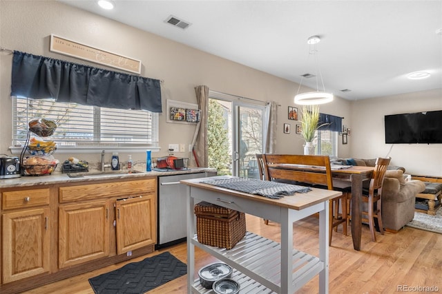19707 E 59th Pl, Aurora, CO 80019 - kitchen with light countertops, visible vents, stainless steel dishwasher, light wood finished floors, and a sink