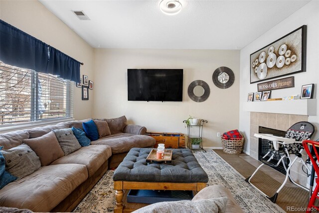 19707 E 59th Pl, Aurora, CO 80019 - living area with a tile fireplace, visible vents, and baseboards