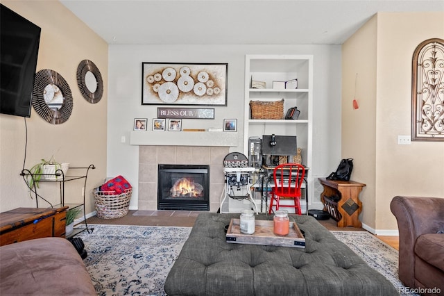 19707 E 59th Pl, Aurora, CO 80019 - living room featuring a tiled fireplace, built in shelves, and baseboards