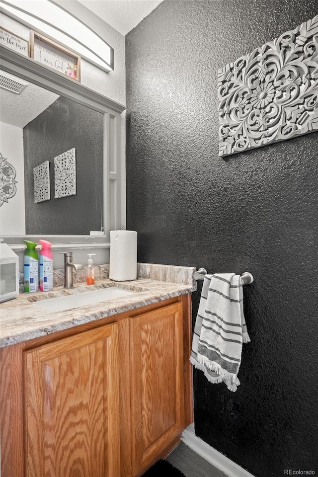 19707 E 59th Pl, Aurora, CO 80019 - bathroom with visible vents, a textured wall, and vanity