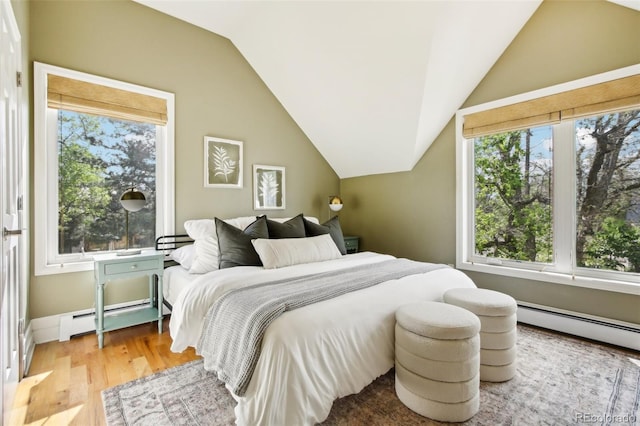 bedroom with baseboard heating, multiple windows, vaulted ceiling, and wood finished floors