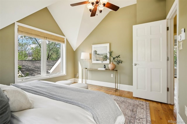 bedroom featuring wood finished floors, lofted ceiling, baseboards, and ceiling fan