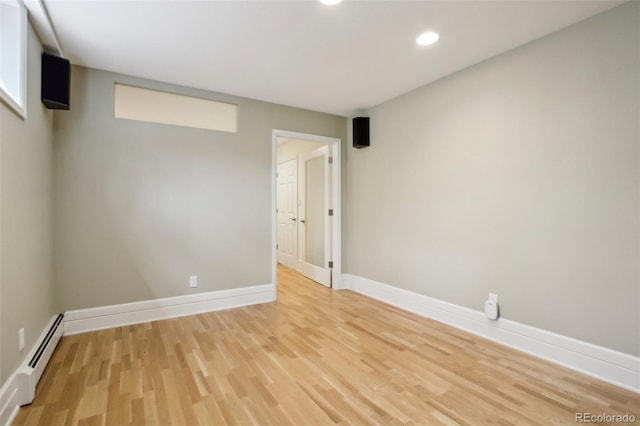unfurnished room featuring a baseboard radiator, light wood finished floors, recessed lighting, and baseboards