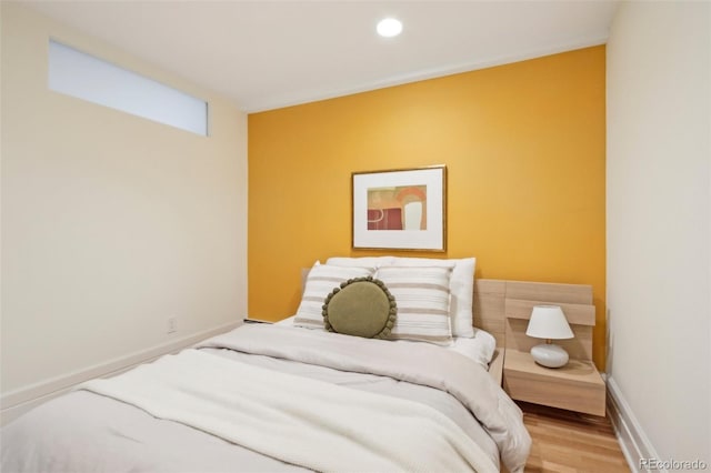 bedroom with wood finished floors, baseboards, and recessed lighting