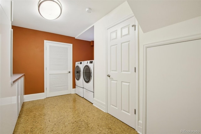 washroom featuring washing machine and dryer and baseboards