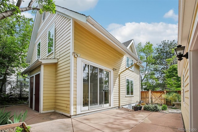 view of property exterior with a patio area and fence